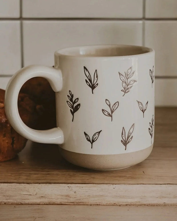 Cream glazed ceramic mug with brown leaf design by Sweet Water Decor, perfect for kitchen and dining use.
