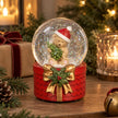 Christmas teddy bear glitter snow globe styled with pinecones, fairy lights and wrapped gifts