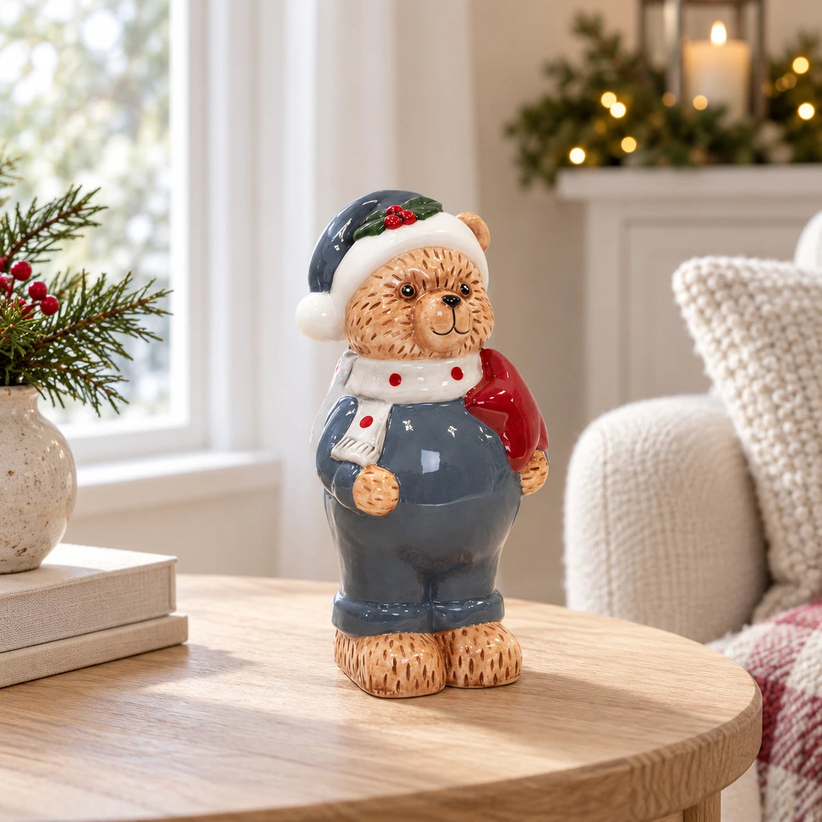Blue teddy bear ornament with white scarf and red detail beside a bright window