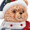 Close-up of the winter blue bear's glazed face, textured fur, white scarf and red dots