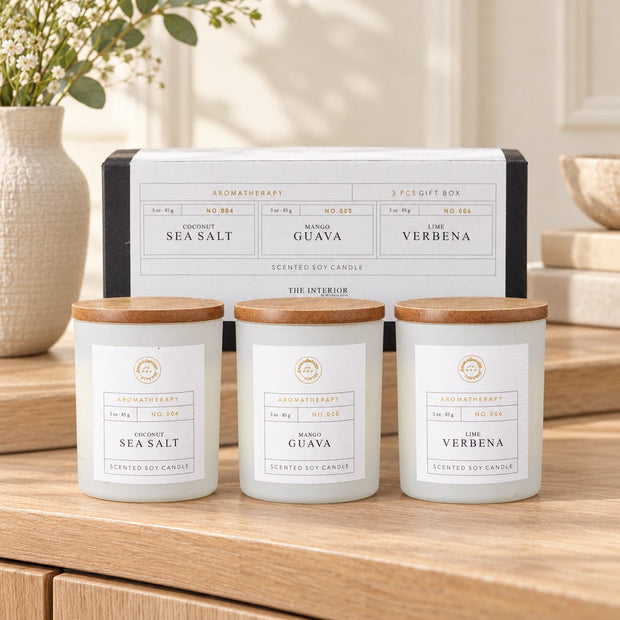 Therapy Candles Gift Set - Set Of Three — Three closed jars in a row with box behind on pale oak sideboard