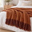 Tweedie cinnamon brushed herringbone throw layered across white linen bedding