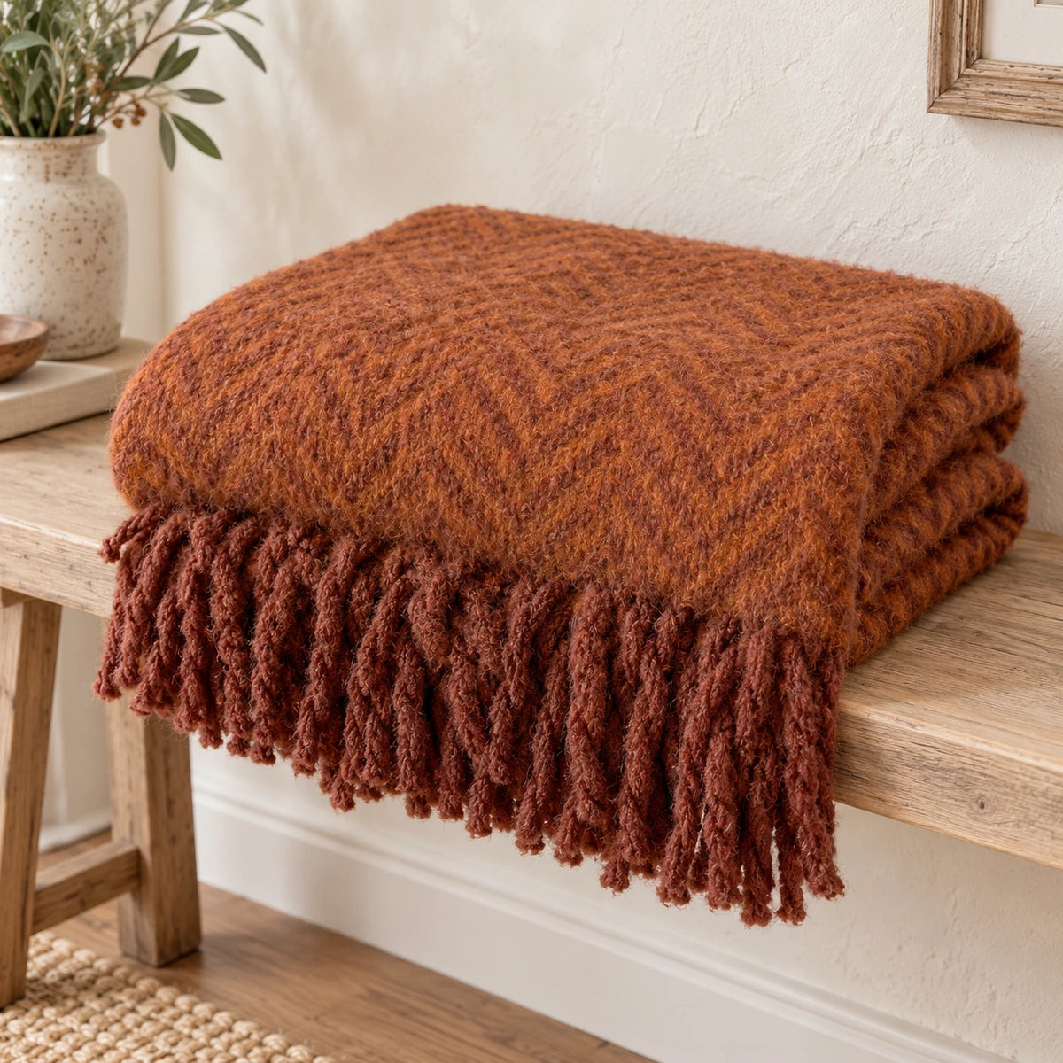 Tweedie cinnamon brushed herringbone throw folded on a pale oak bench