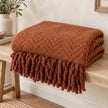 Tweedie cinnamon brushed herringbone throw folded on a pale oak bench
