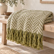Tweedie green brushed herringbone throw folded on a pale oak bench