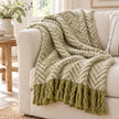 Tweedie green brushed herringbone throw draped over a cream sofa