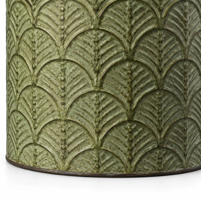 Close-up of the aged green finish, raised leaf design and lower edge of a metal planter
