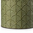 Close-up of the aged green finish, raised leaf design and lower edge of a metal planter