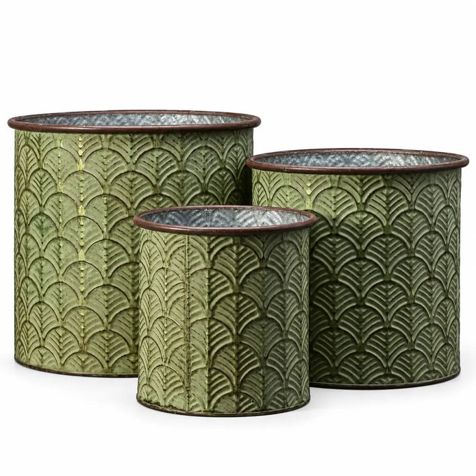 Three empty vintage green cylindrical metal planters with embossed leaf patterns and brown rims on white
