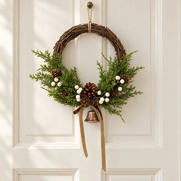 Medium Satchville Christmas twig wreath with white berries, pinecones, bells, and bow detail for door decoration.