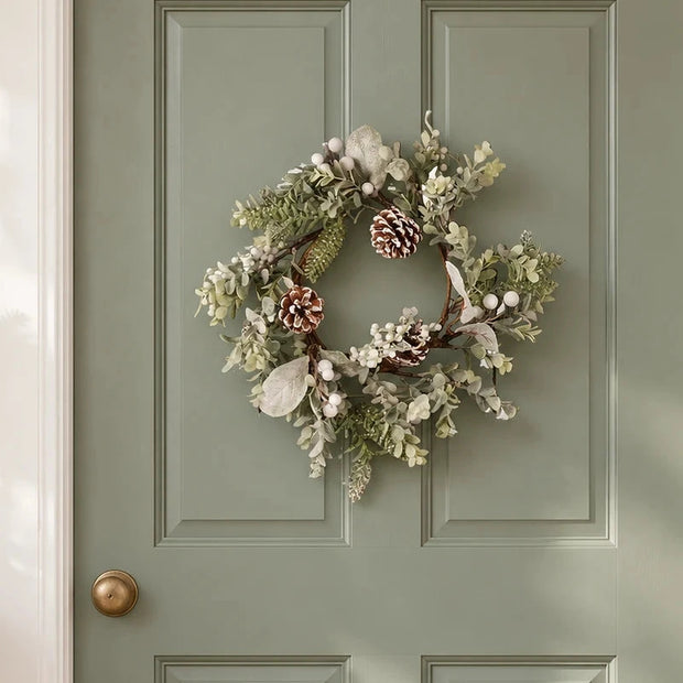 White Berry Wreath with frosted foliage and pinecones on a sage interior door