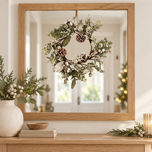 White Berry Wreath displayed over an oak-framed mirror in a neutral Christmas hallway