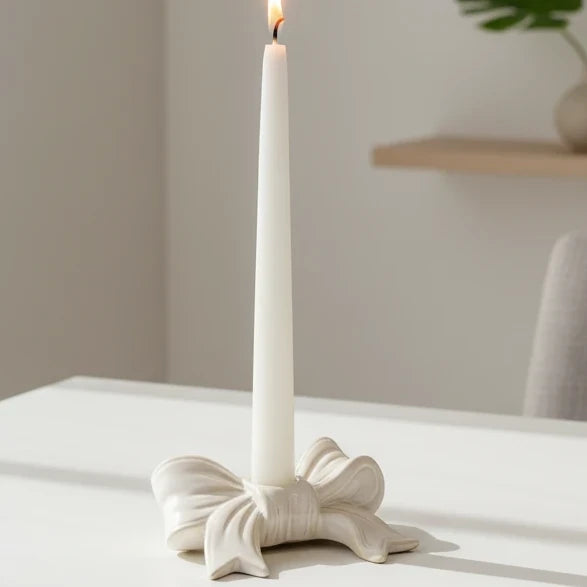White ceramic dinner candle holder with a bow design, ideal for elegant home decor by Satchville.