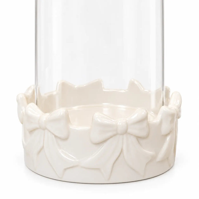 Close-up of raised ceramic bows and clear glass on the white hurricane candle holder