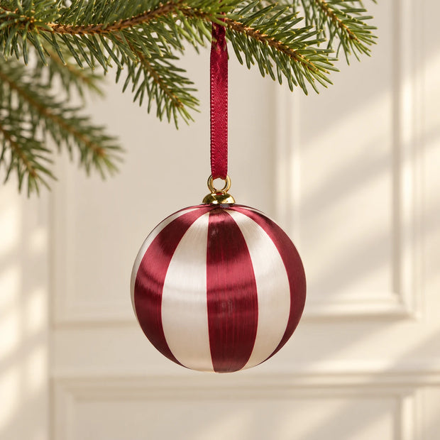 White & Burgundy Christmas Hanging Baubles — Only wide-stripe bauble hanging from fir branch before cream panelled wall