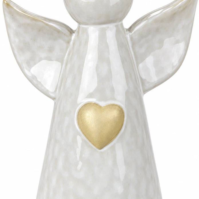White studio close-up of the pale gold heart detail and glossy pearly glaze on the ceramic angel ornament.