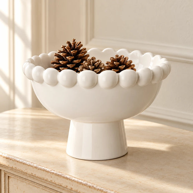 White Ceramic Bobble Footed Bowl — Bowl on warm cream console with three small natural pine cones inside
