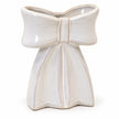 White ceramic bow vase showing sculpted loops, centre knot and glossy glaze on white