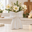 Large white ceramic bow vase with cream flowers in a bright country kitchen