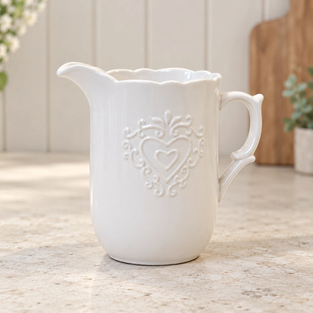 White ceramic heart jug on a pale stone cottage kitchen worktop