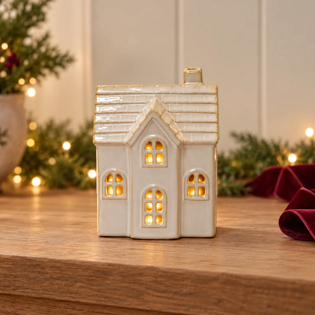 Satchville white ceramic Christmas LED house with arched windows on a console