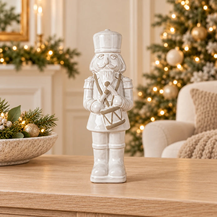 33cm large white glazed ceramic nutcracker drummer on an oak console with neutral Christmas styling