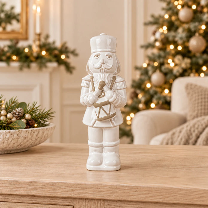 26cm medium white glazed ceramic nutcracker drummer on an oak console with neutral Christmas styling
