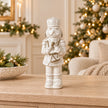 21cm small white glazed ceramic nutcracker drummer on an oak console with neutral Christmas styling