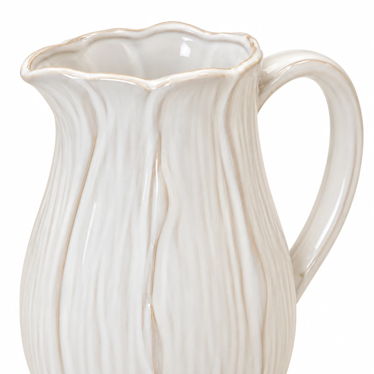 Close-up of the large white ceramic jug's scalloped petal rim and glazed handle