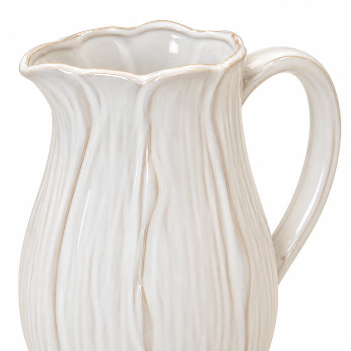 Close-up of the large white ceramic jug's scalloped petal rim and glazed handle