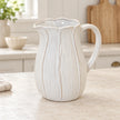 Large white ceramic petal jug on a light stone kitchen worktop