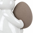 Small white ceramic rabbit holding a taupe egg, 18cm tall, white studio close-up of the glossy paw and textured egg.