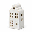 Complete empty white ceramic house tealight holder with stepped roof on white
