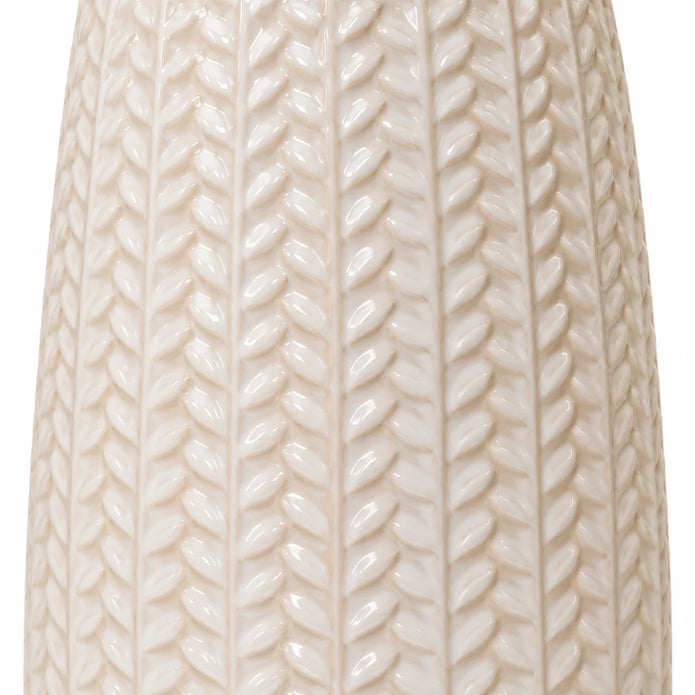 Close-up of the glossy white leaf relief pattern on the ceramic vase