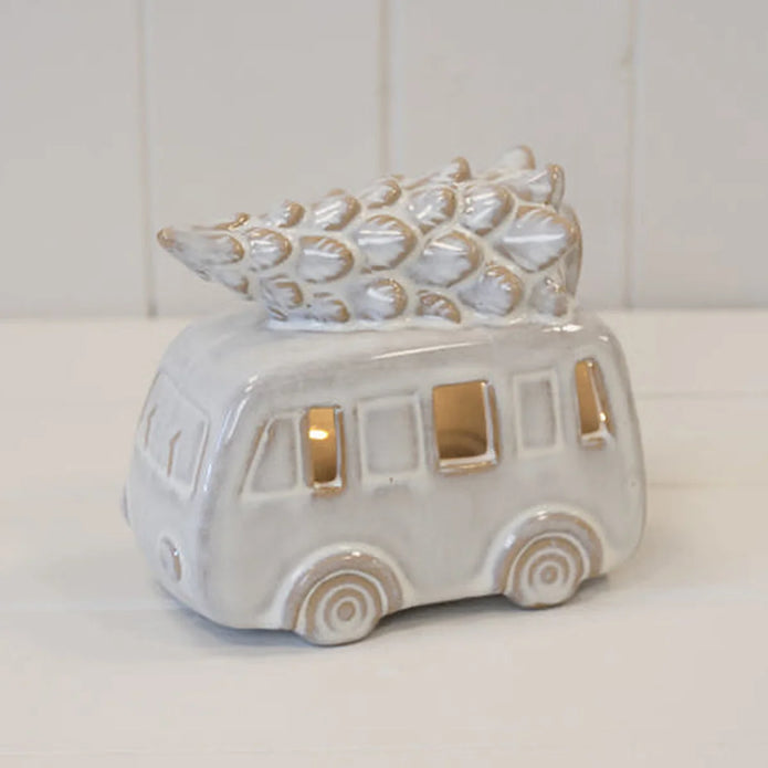White ceramic LED camper van with Christmas tree on roof on a plain studio background, unlit