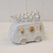 White ceramic LED camper van with Christmas tree on roof on a plain studio background, unlit
