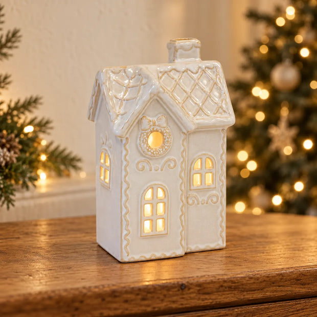 White LED Christmas decorated townhouse by Satchville, illuminated holiday decor with festive lights and winter scene.