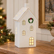 Large white LED house with wreath on a Christmas console table