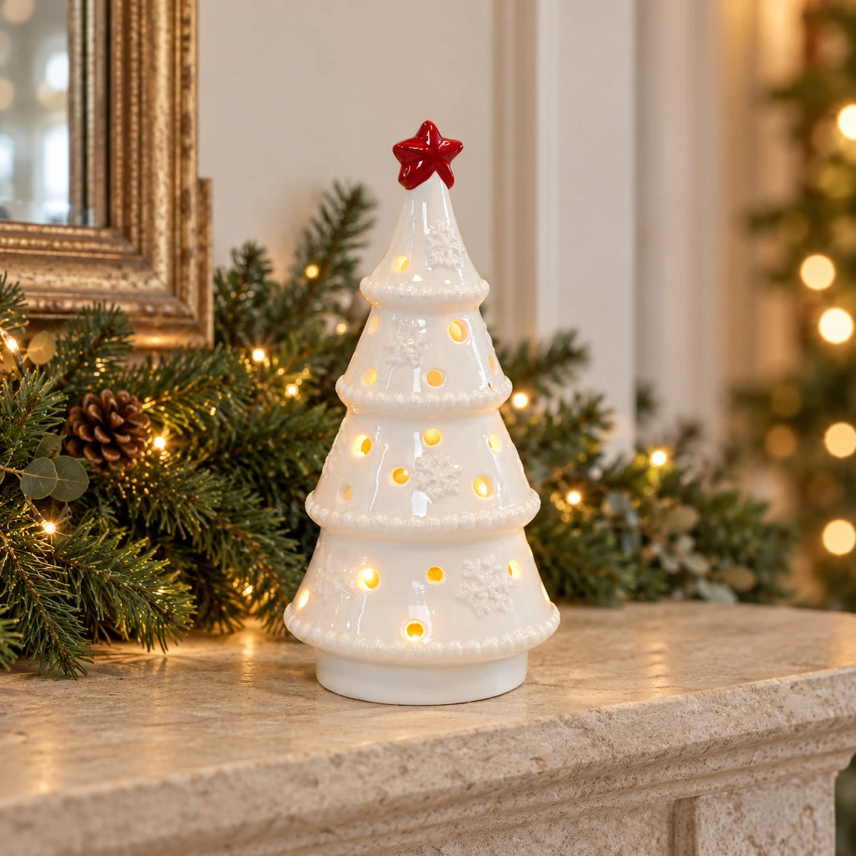 White LED Christmas tree with red star on a festive stone mantel.