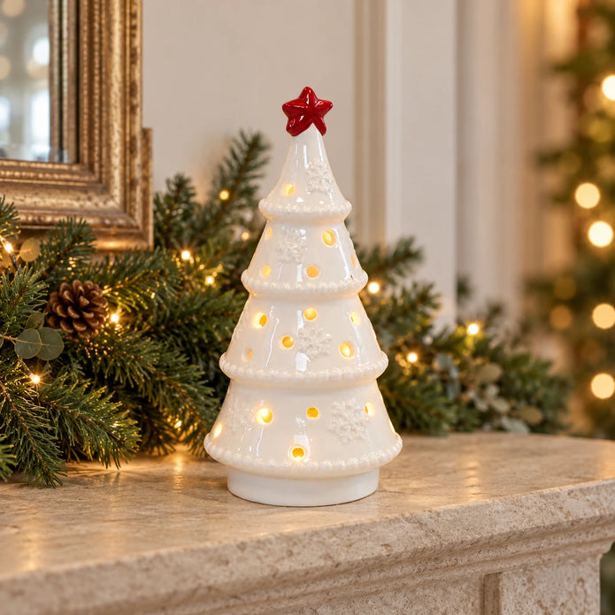 White LED Christmas tree with red star on a festive stone mantel.