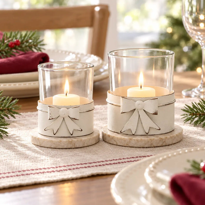 Small and large white bow tealight holders with candles in a festive country dining table display