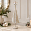 Large white metal Christmas tree with gold stars styled on a neutral sideboard