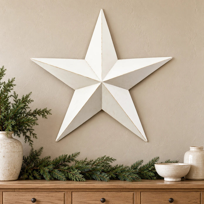 Extra large white metal wall star above an oak console with Christmas greenery