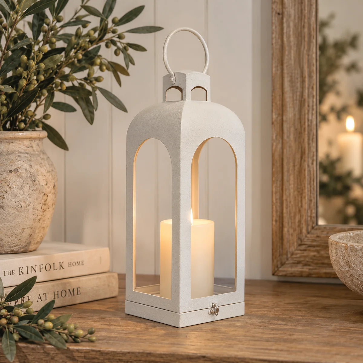 Off-white arched metal candle lantern with ring handle in neutral country home interior