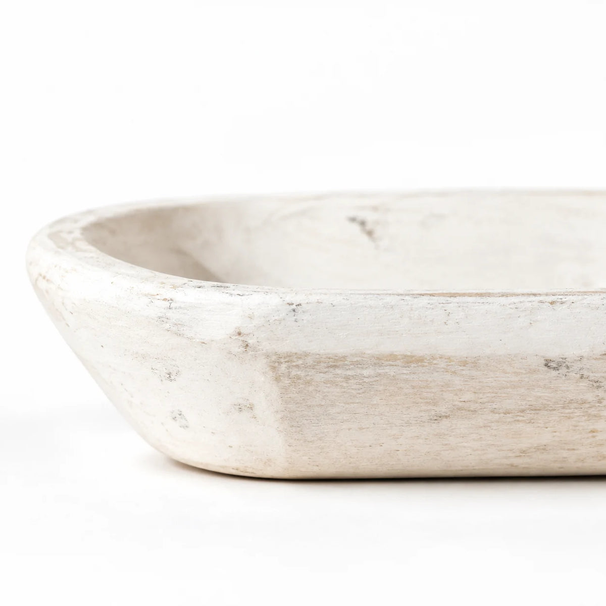 Close-up of the white mini dough bowl’s curved side and resting base, showing its rustic painted finish.
