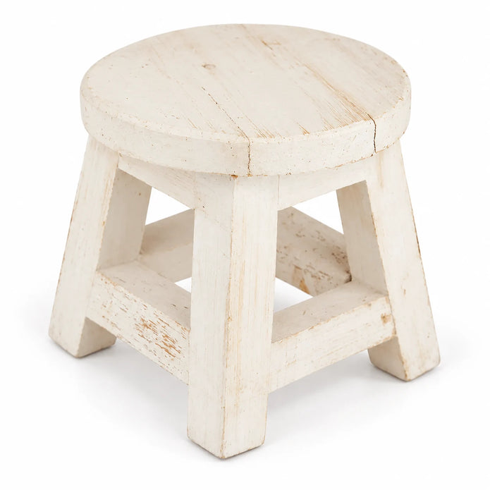 White rustic wooden mini stool with a round top, splayed legs and lower crossbars, shown alone against white.