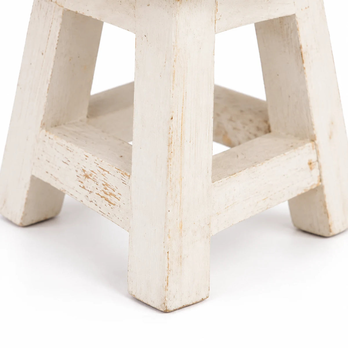 Close-up of the white mini stool’s legs and crossbars, showing worn paint and handcrafted wooden construction.