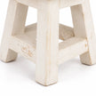 Close-up of the white mini stool’s legs and crossbars, showing worn paint and handcrafted wooden construction.