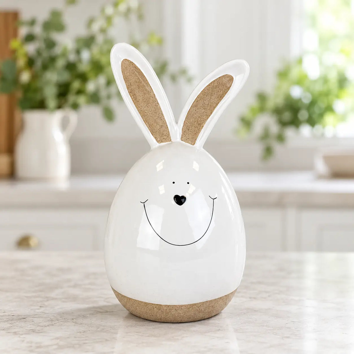White ceramic rabbit on a pale kitchen counter with green foliage behind.