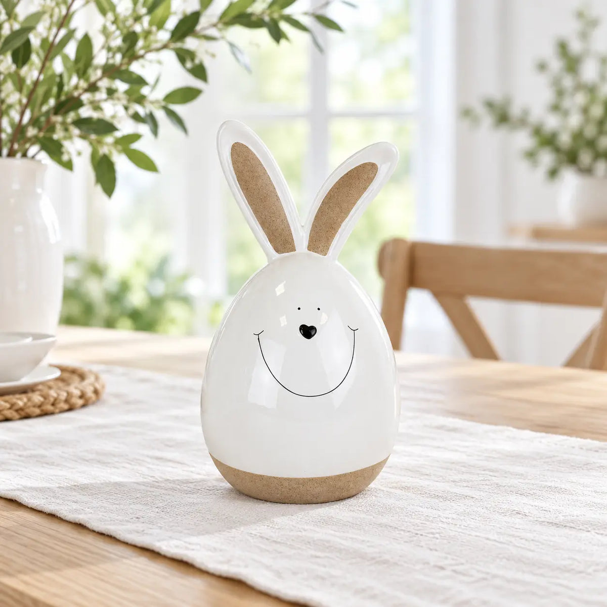 Small white ceramic rabbit on a linen runner on an oak dining table.